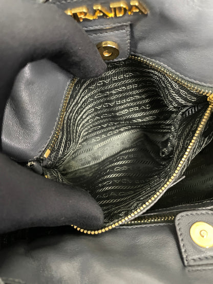 Close-up view of Prada logo and interior zippered pocket inside the Tessuto Ruffle Bag in grey nylon.