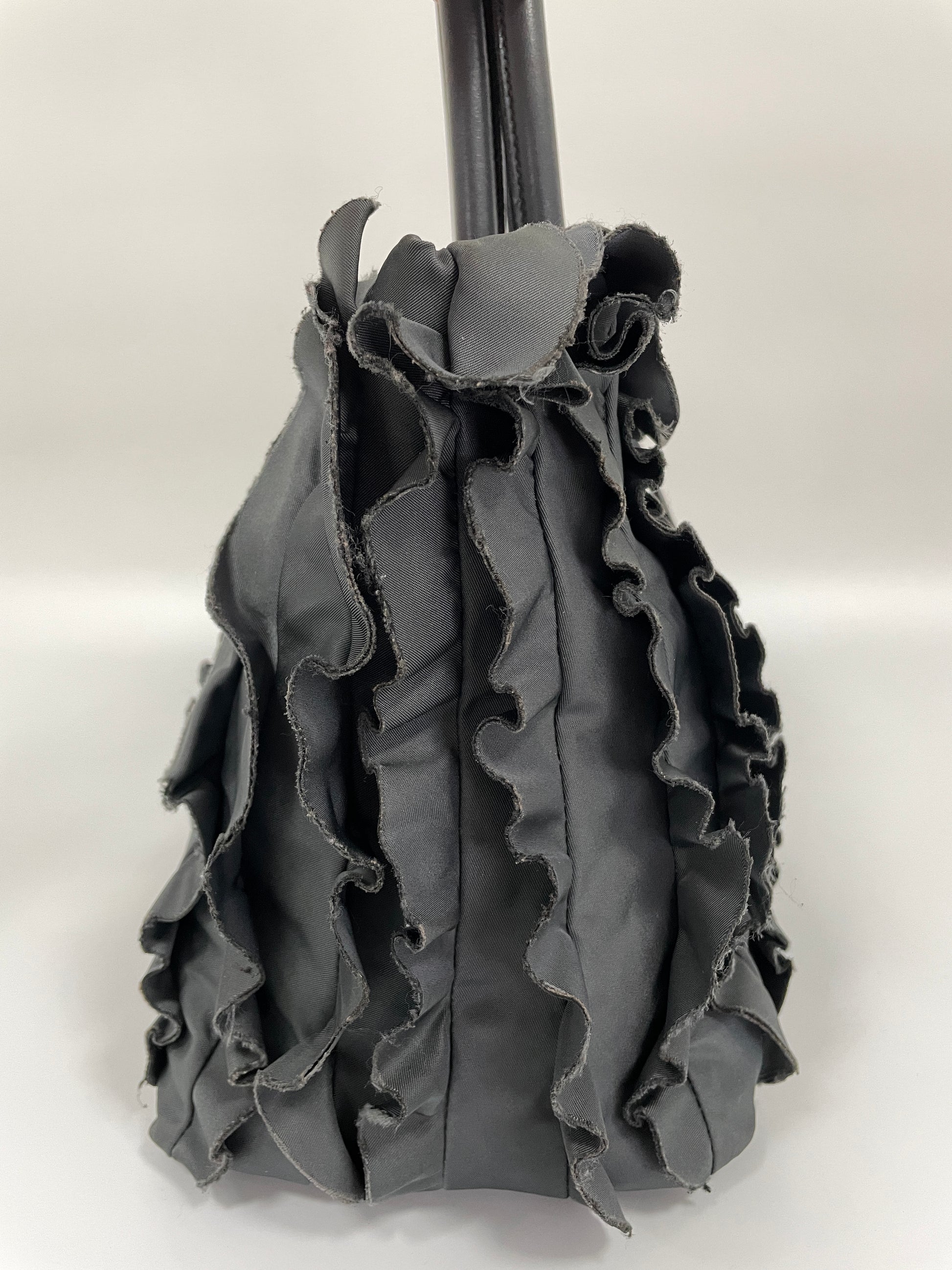 Side view of Prada Tessuto Ruffle Bag in grey nylon showcasing the structured design and ruffle details.