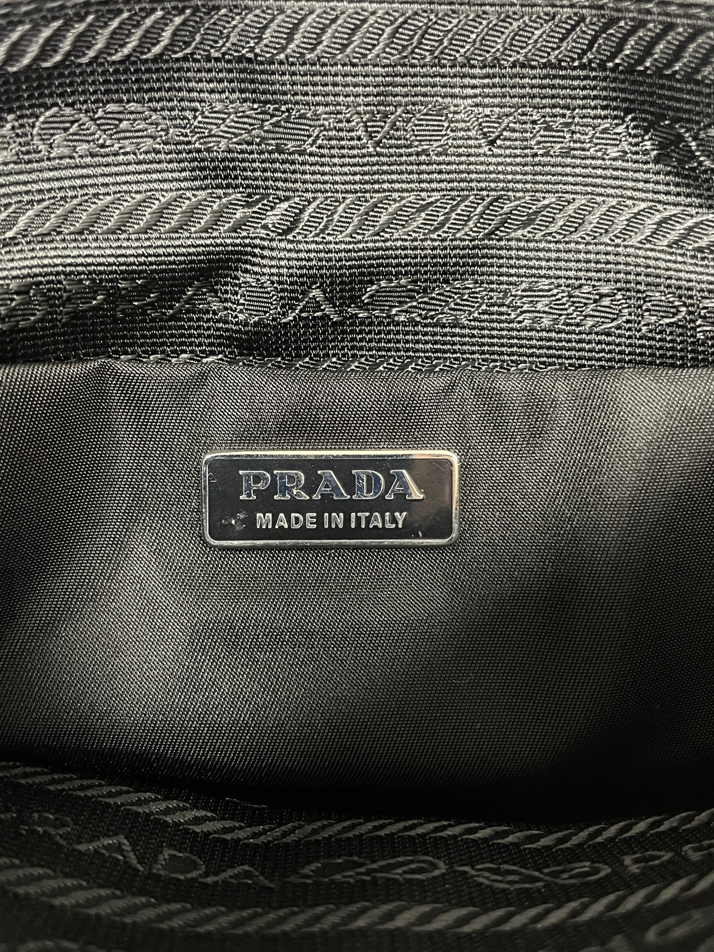 Interior view of the Prada Tessuto Spazzolato bag in indigo prune nylon showing the "Prada Made in Italy" label.