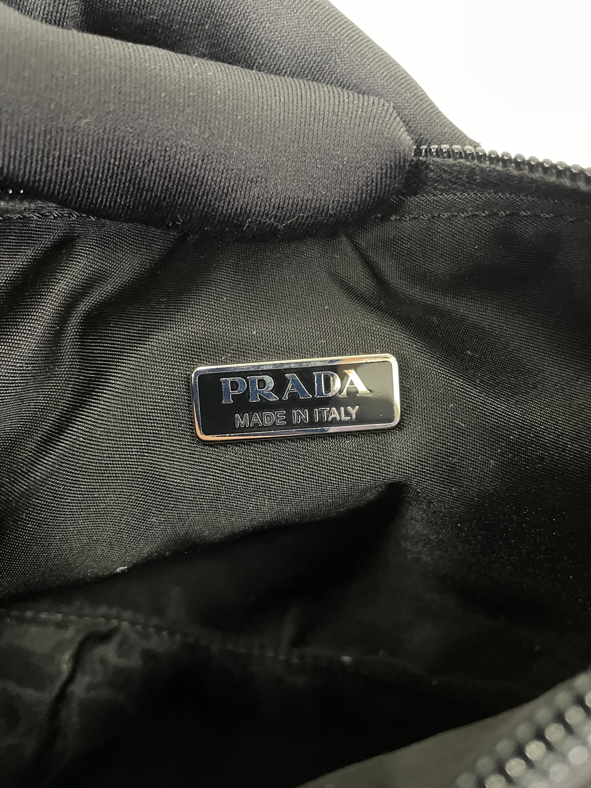 Interior view of the Prada Tessuto Spazzolato bag in indigo prune nylon showing the "Prada Made in Italy" label.