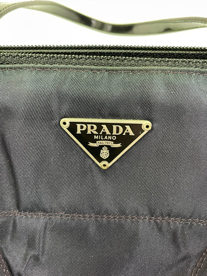 Close-up of a Prada Tessuto Spazzolato bag in indigo prune nylon highlighting the brand's iconic Prada logo.