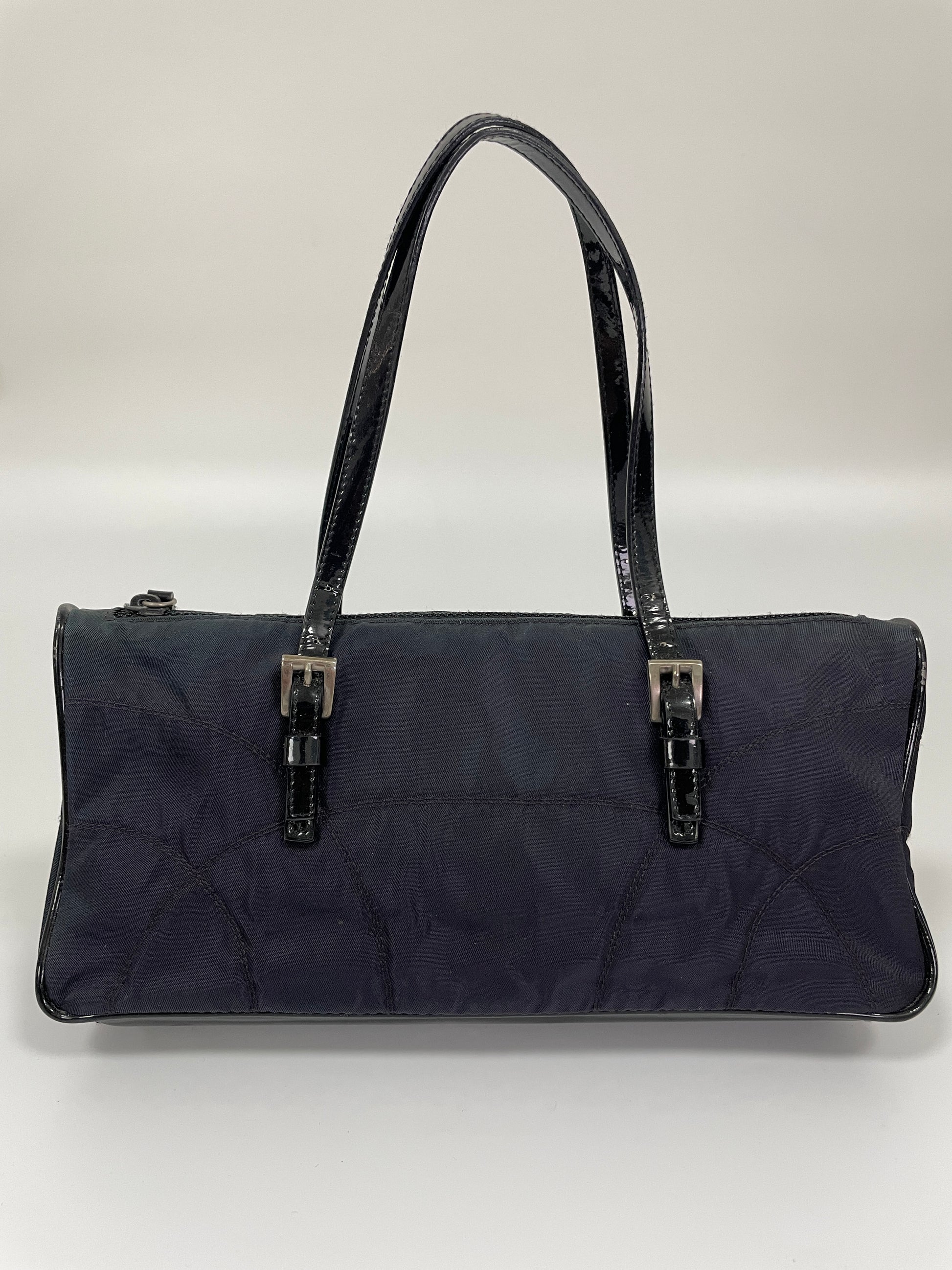 Rear view of a Prada Tessuto Spazzolato bag in indigo prune nylon showcasing its gradient color and leather handles.