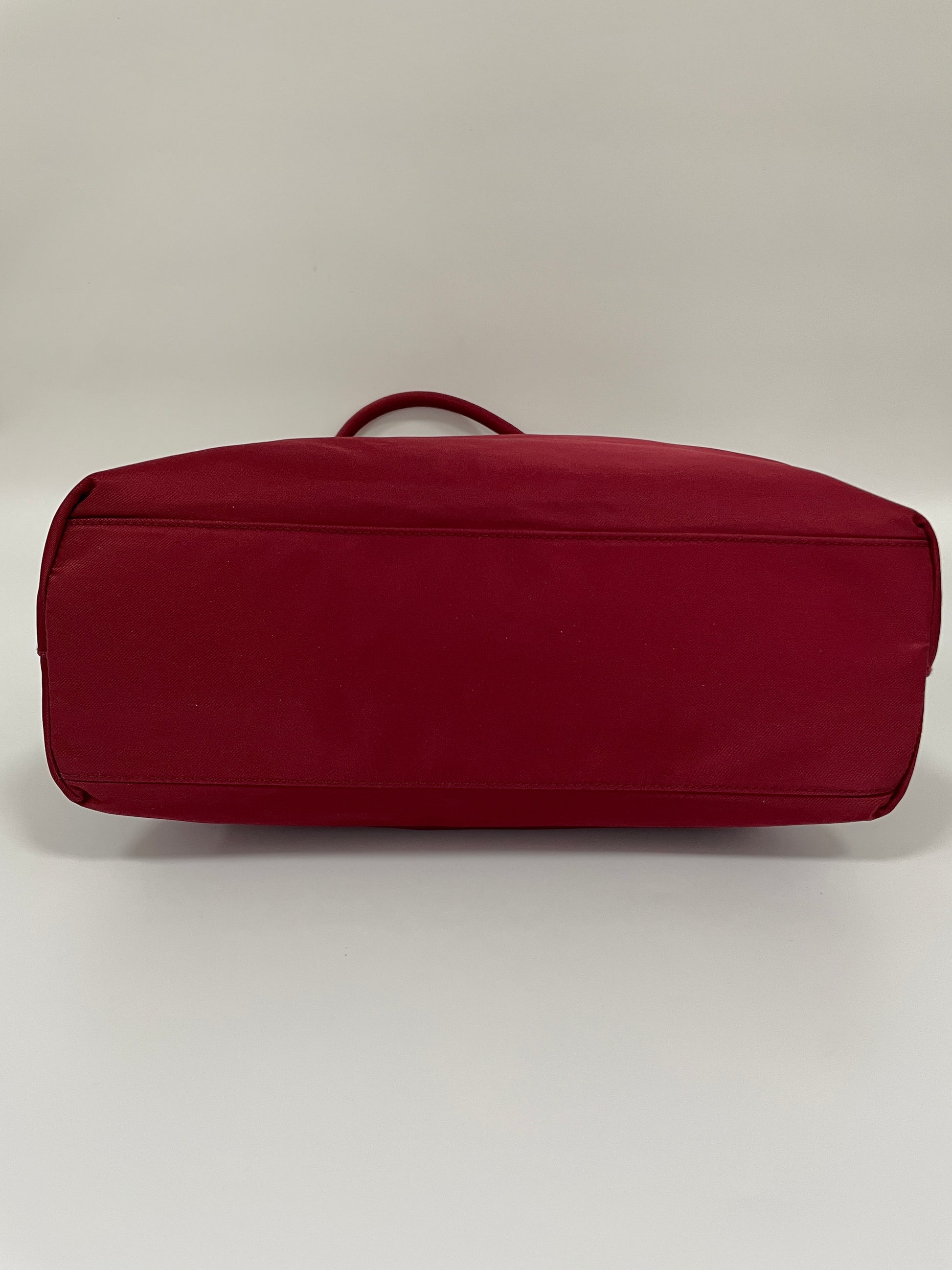 Bottom view of the Prada Tessuto Tote Bag in red nylon showcasing the smooth and clean finish.