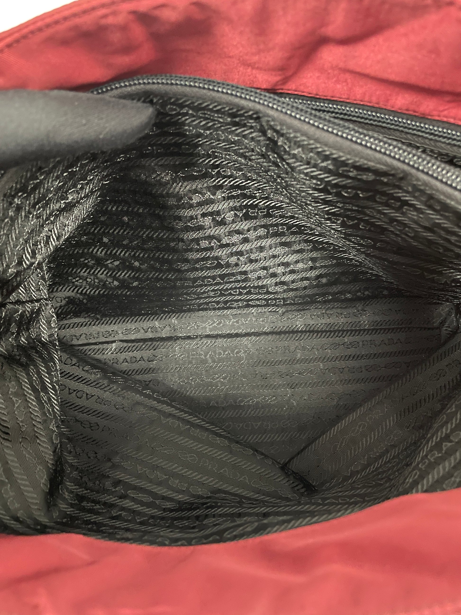 Interior view of the Prada Tessuto Tote Bag in red nylon displaying the spacious black fabric lining and zippered pocket.