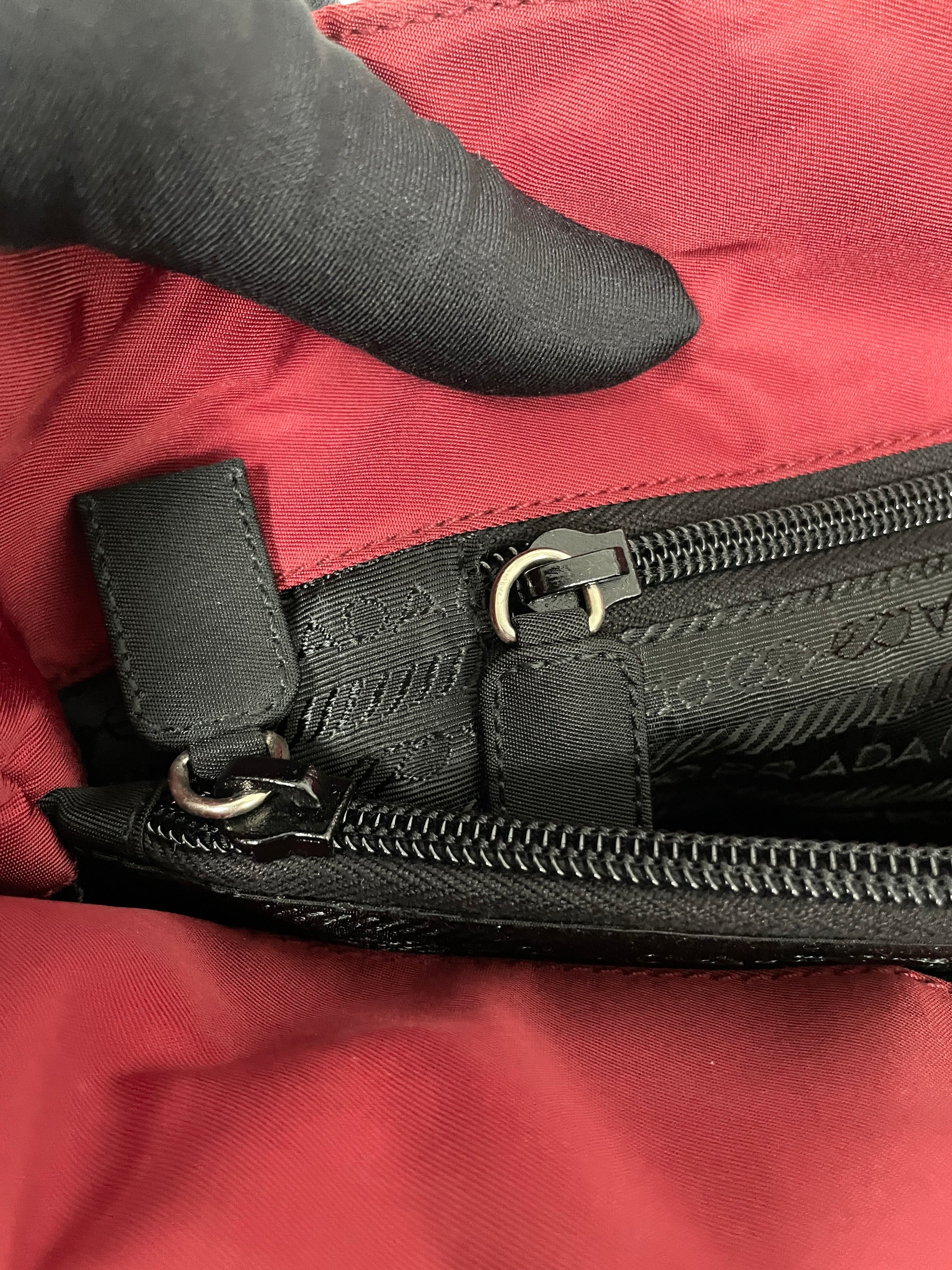 Close-up of the interior zipper detail on the Prada Tessuto Tote Bag in red nylon showcasing the black zippered compartment.