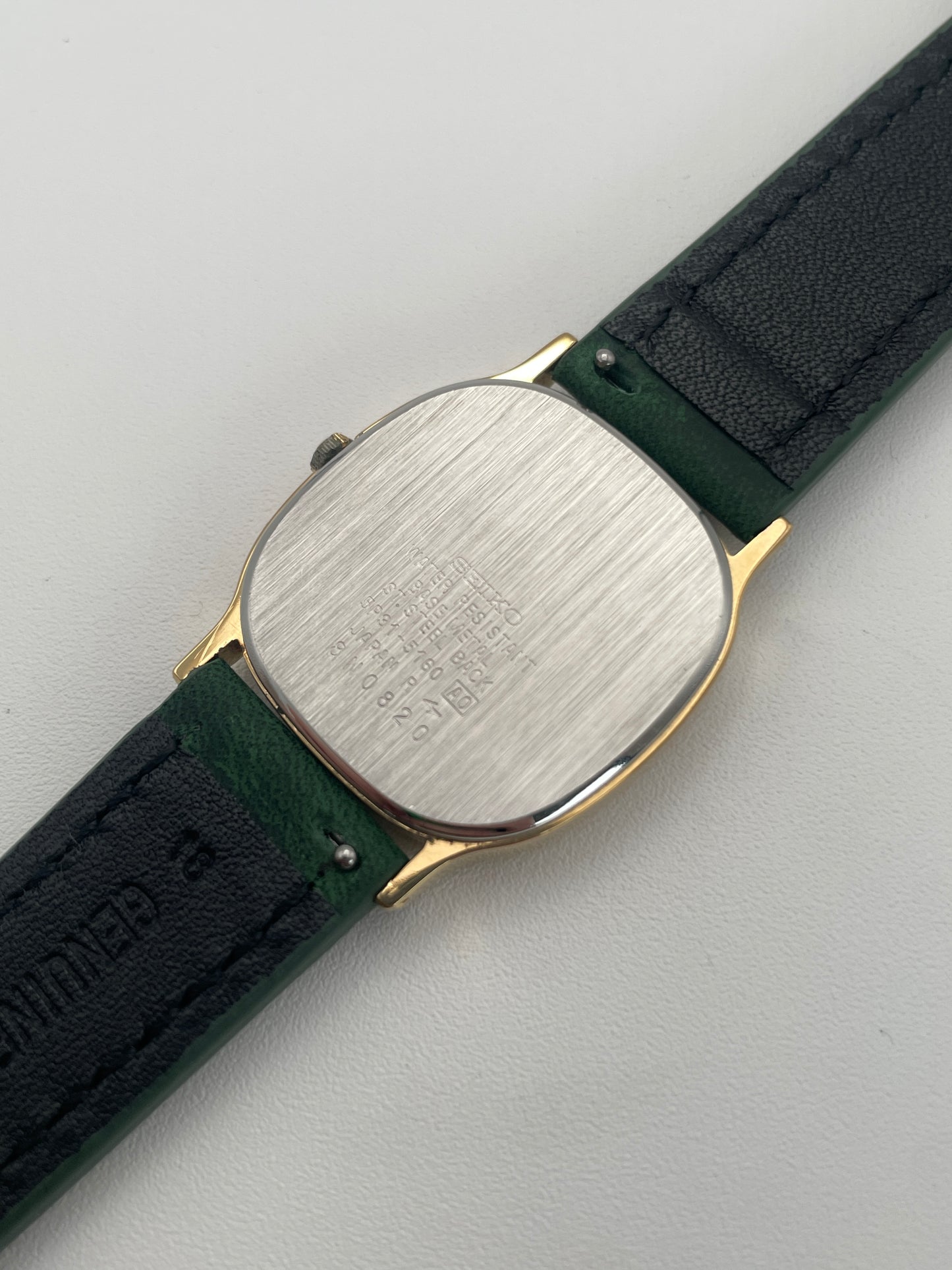 Caseback view of Seiko Chariot with detailed engravings and green leather strap.