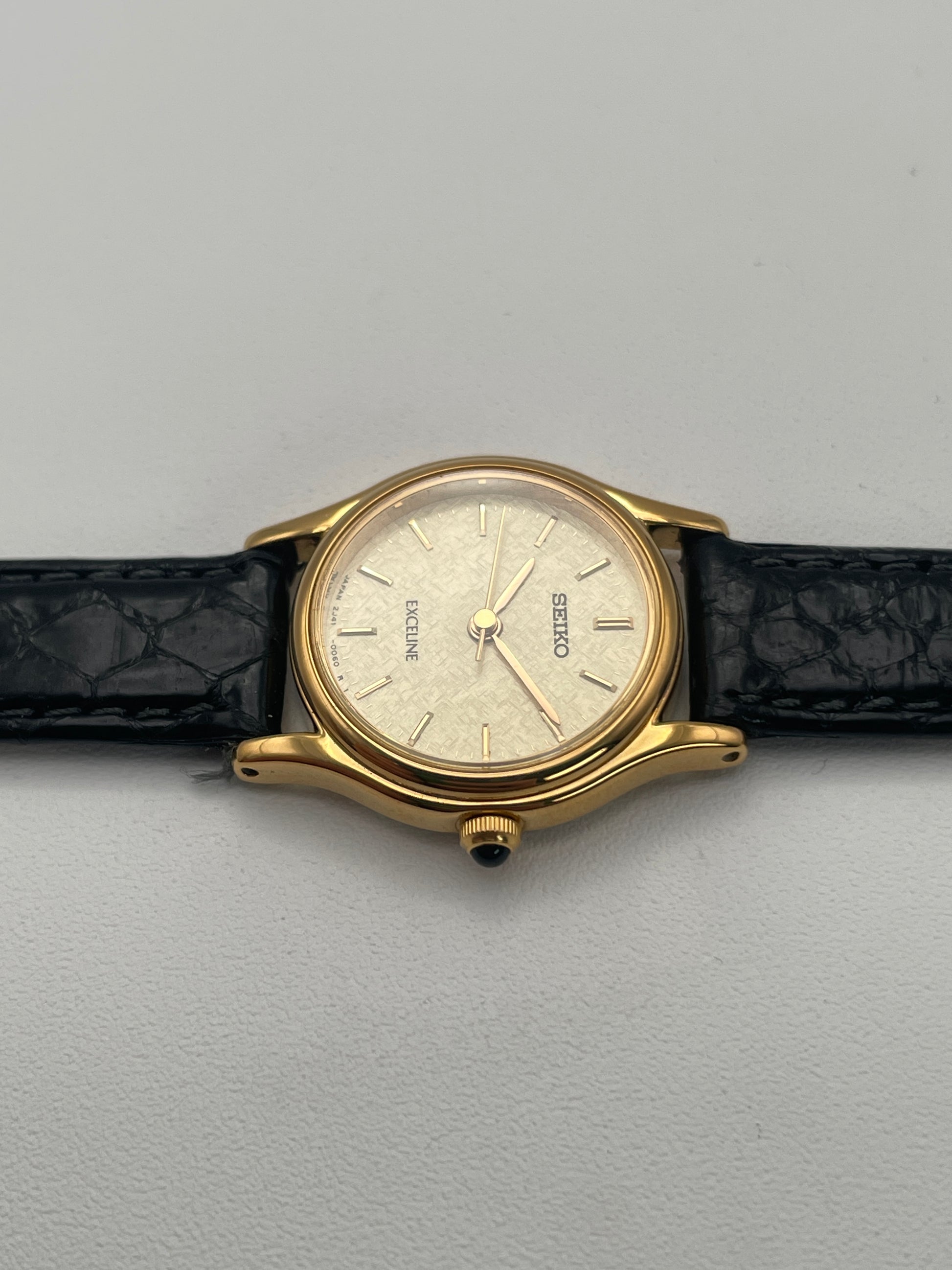 Right profile view of Seiko Exceline gold watch, emphasizing the gold crown and case.