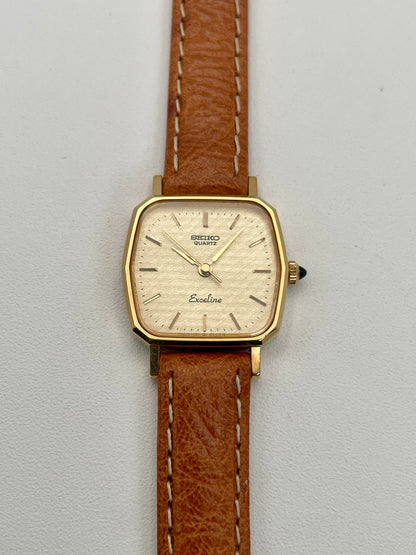 Front view of Seiko Exceline vintage women's watch in gold with tan leather strap, highlighting the unique octagonal case shape.

