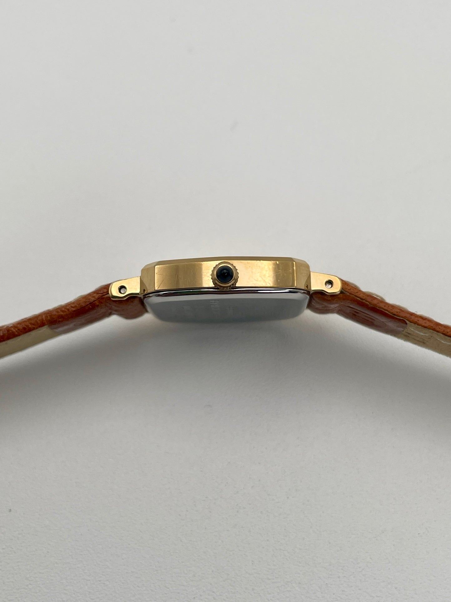 Close-up of the crown side of the Seiko Exceline vintage watch in gold, attached to a tan leather strap.