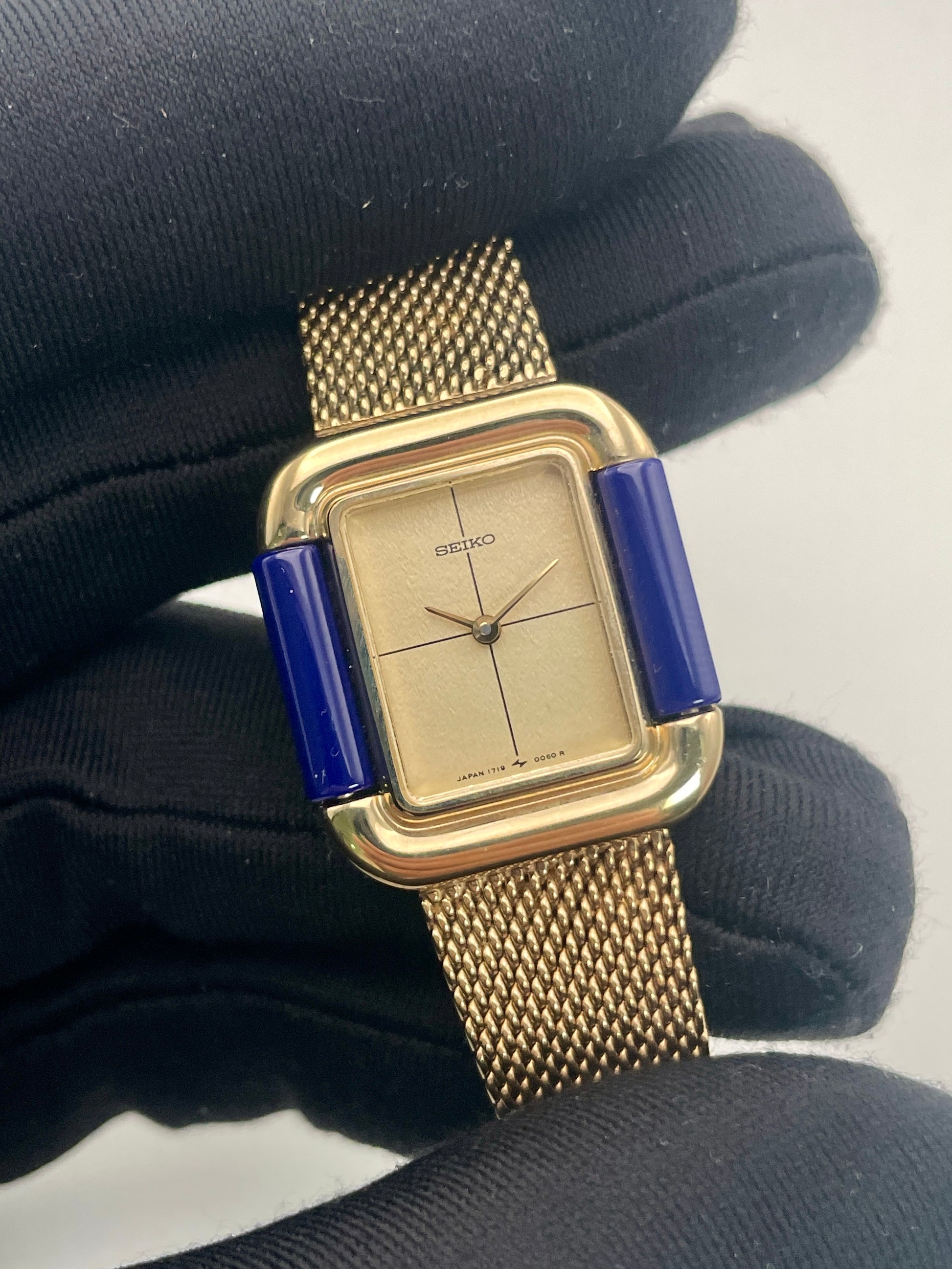 Handheld close-up of Seiko Hidden Crown 1719-3070 vintage ladies' watch focusing on its champagne dial and blue accents.