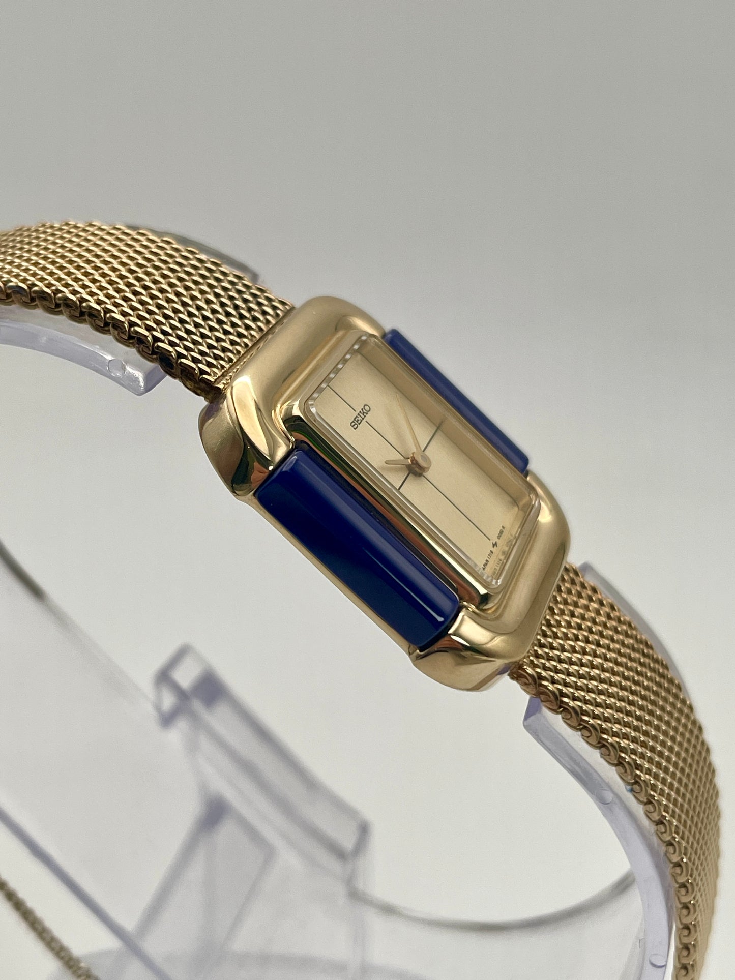 Side angle view of Seiko Hidden Crown 1719-3070 watch showing gold case and integrated mesh bracelet.