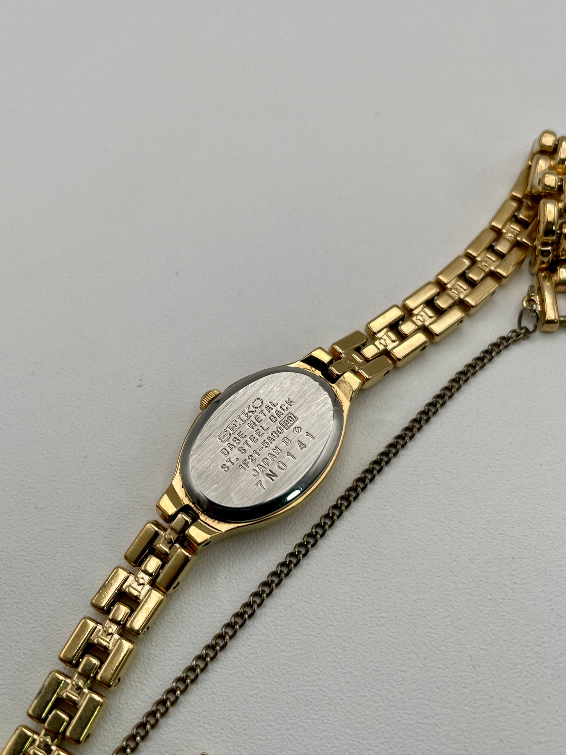 Caseback view of Seiko Oval 1F21-5A00 with model number and stainless steel markings
