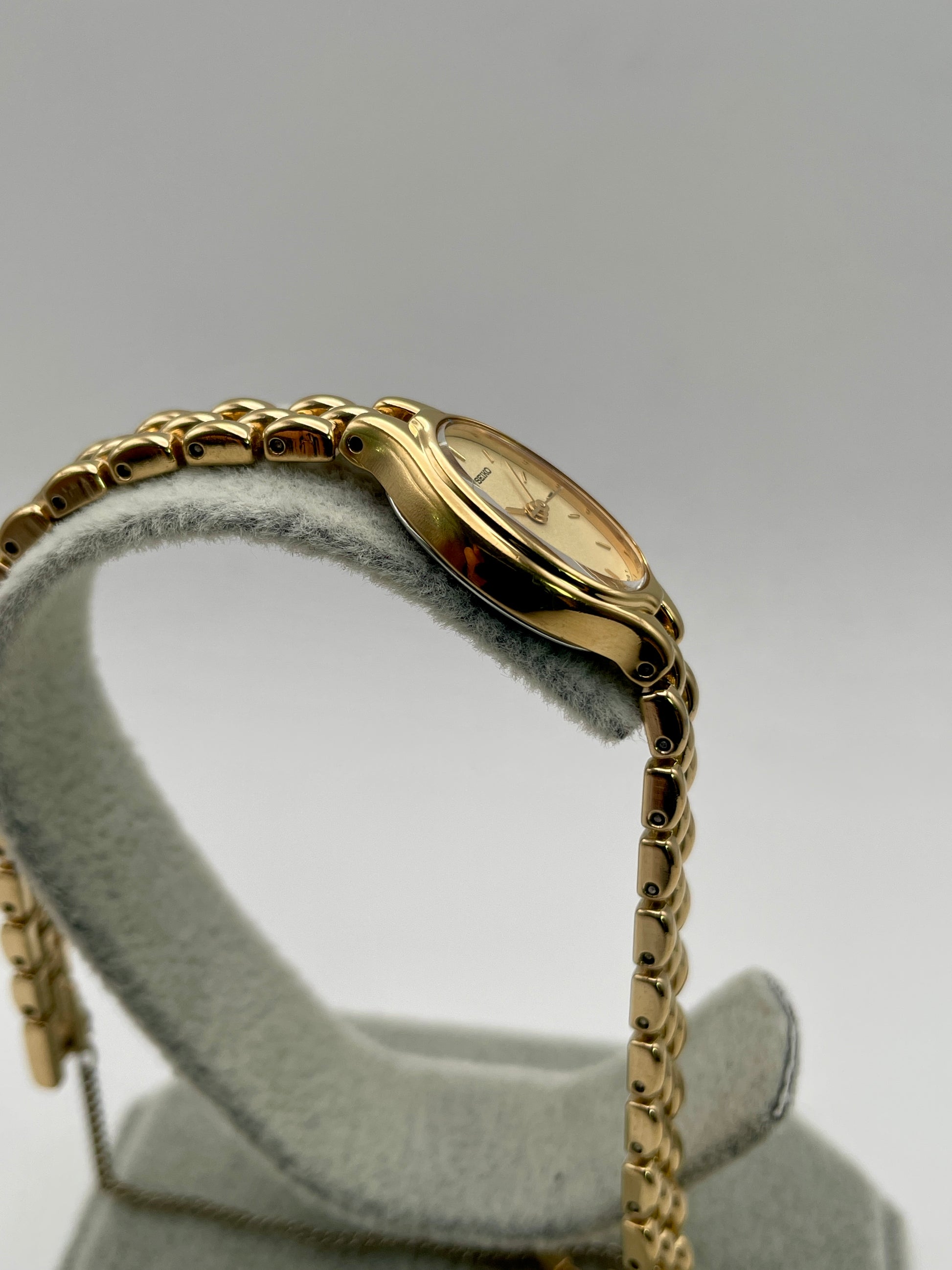 Side case view of Seiko Oval 1F21-5A00 showing smooth contours of the gold-tone case
