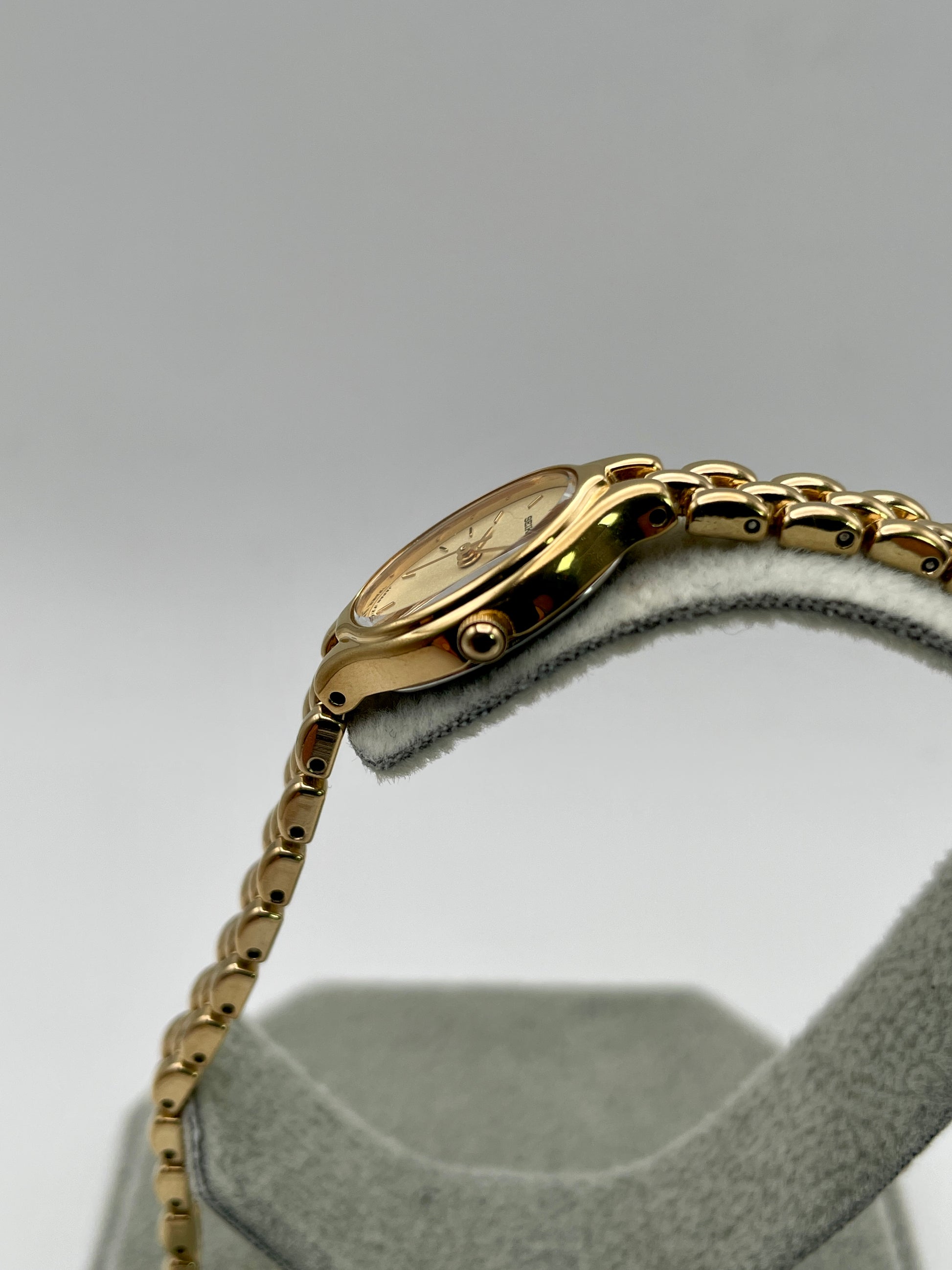 Side view of Seiko Oval 1F21-5A00 focusing on the gold-tone crown and case profile
