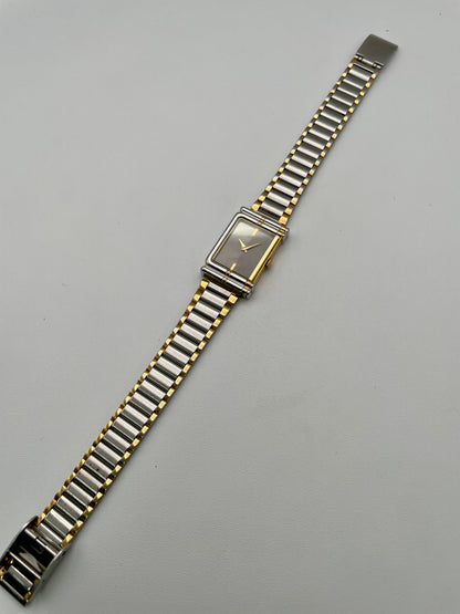 Full view of the Seiko Porte watch with its integrated two-tone bracelet laid flat
