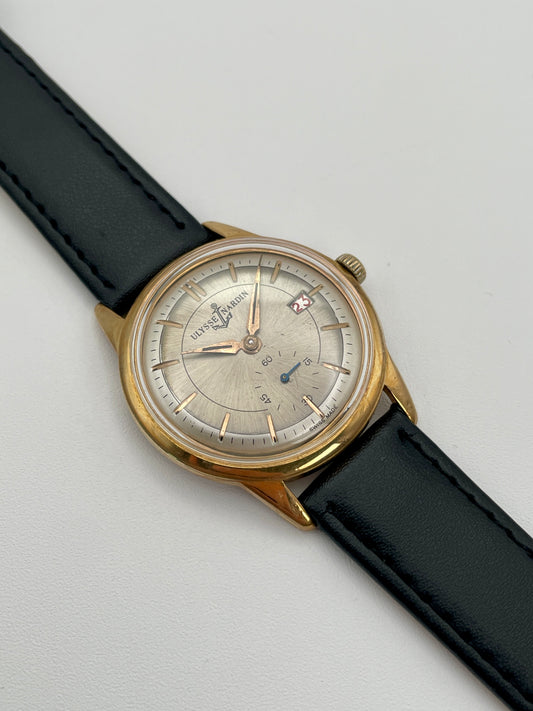 Main view of Ulysse Nardin gold vintage watch with silver dial and black leather strap
