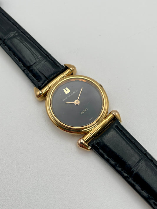 Universal Geneve 542.678 vintage women's watch in gold with black dial and black leather strap, main view
