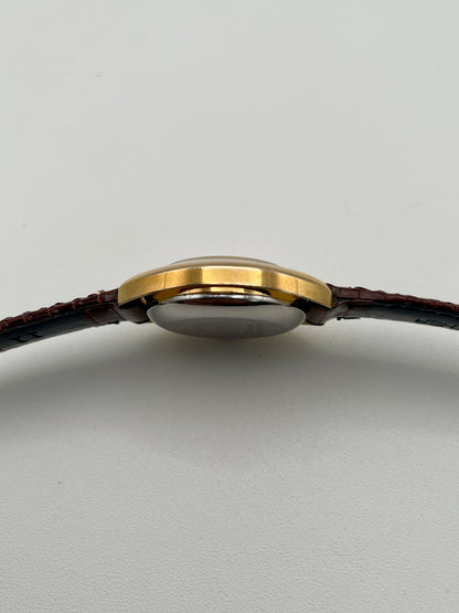 Side profile showing the slim gold case and domed crystal
