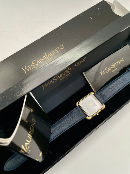 Yves Saint Laurent 3D Square watch with gold case and blue leather strap, shown with original box and papers.