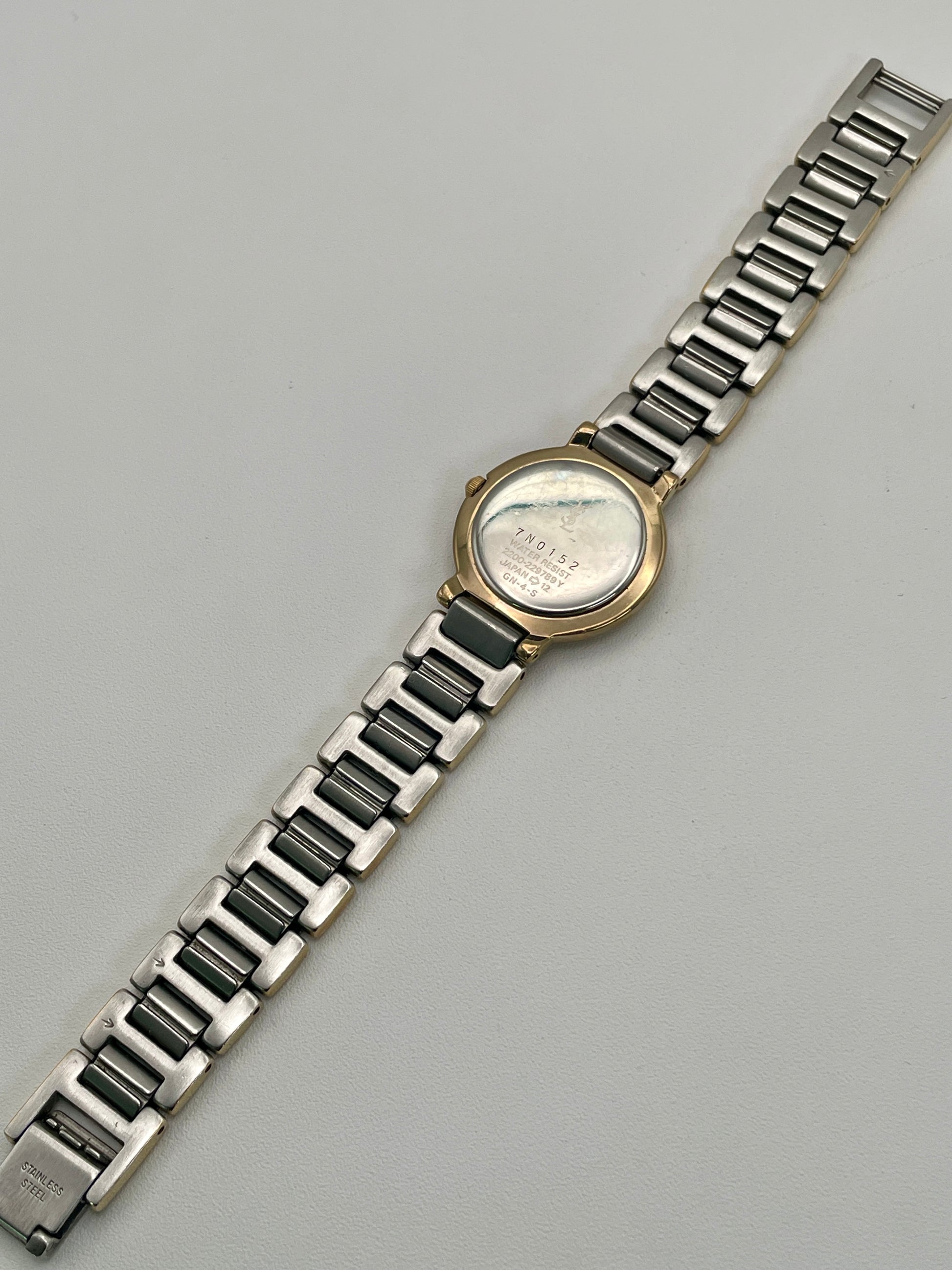 Caseback view of the Yves Saint Laurent Black Pour Femme watch showing model and serial engravings.