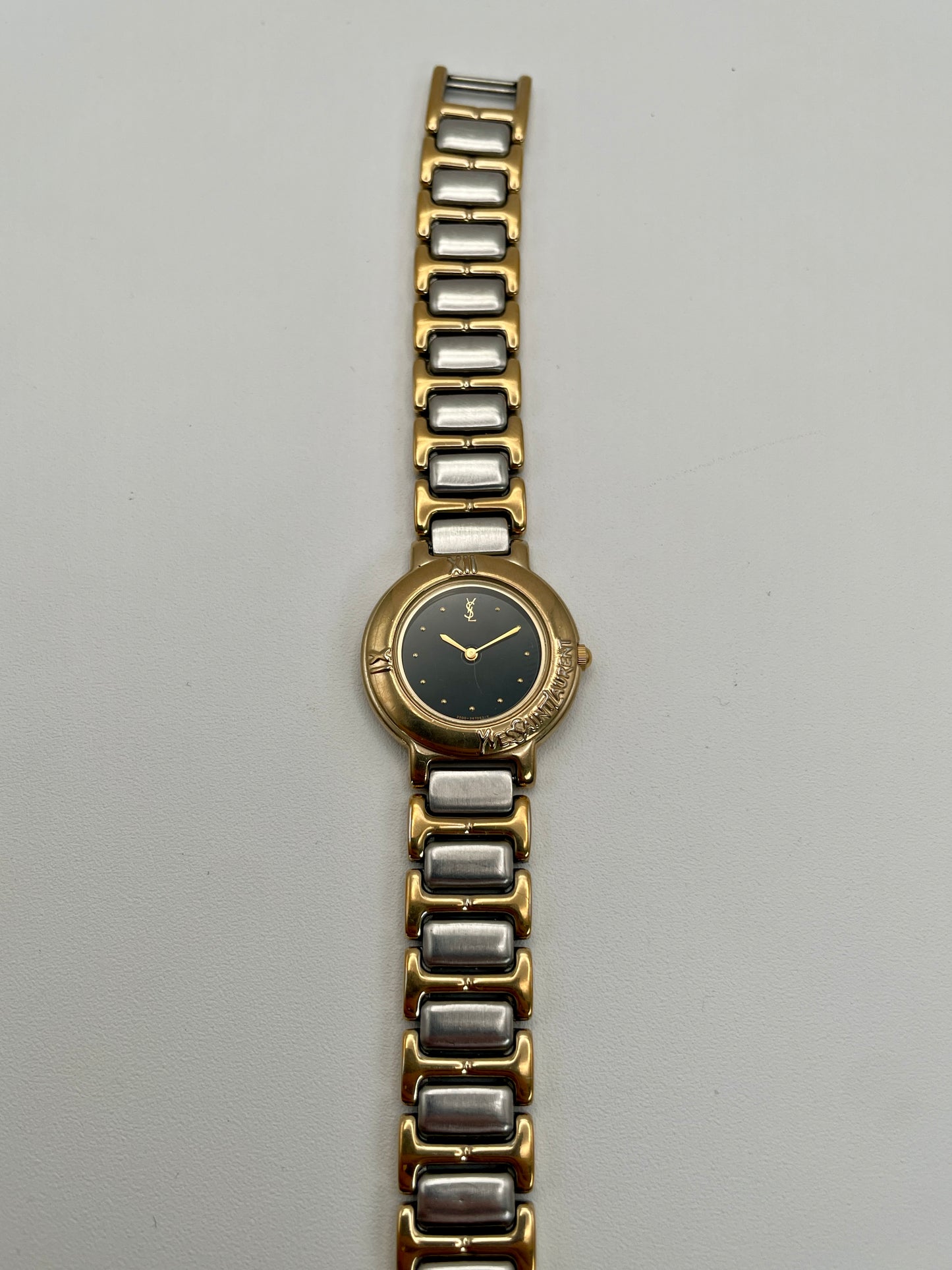 Yves Saint Laurent Black Pour Femme vintage women's watch in a gold case with two-tone bracelet.