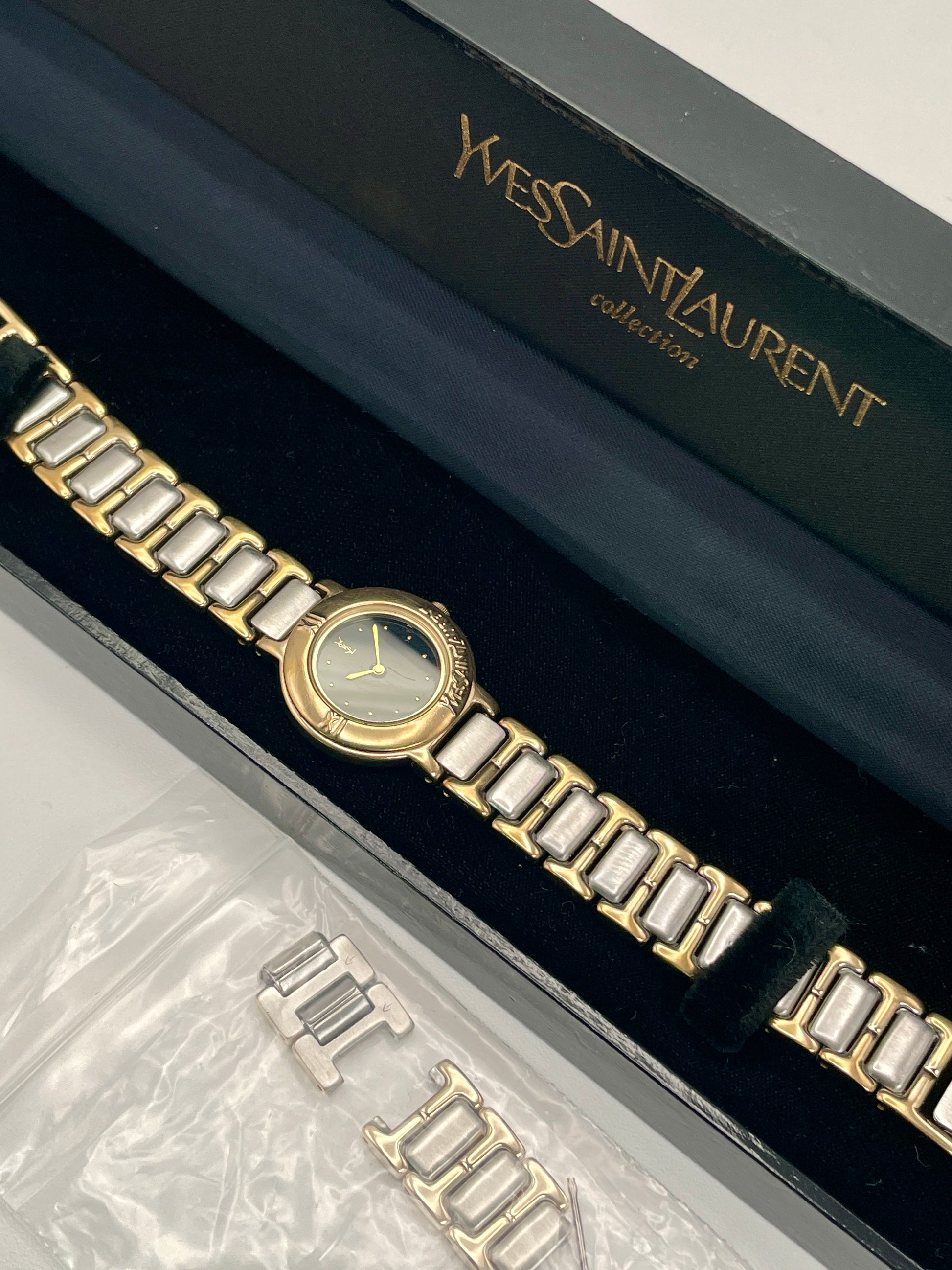 Yves Saint Laurent Black Pour Femme vintage women's watch in a gold case with two-tone bracelet, shown with original box and extra links.