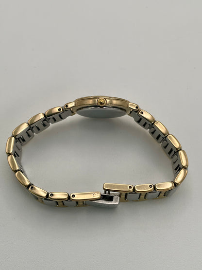 Side view of the YSL watch showing the gold-tone crown and slim case profile.