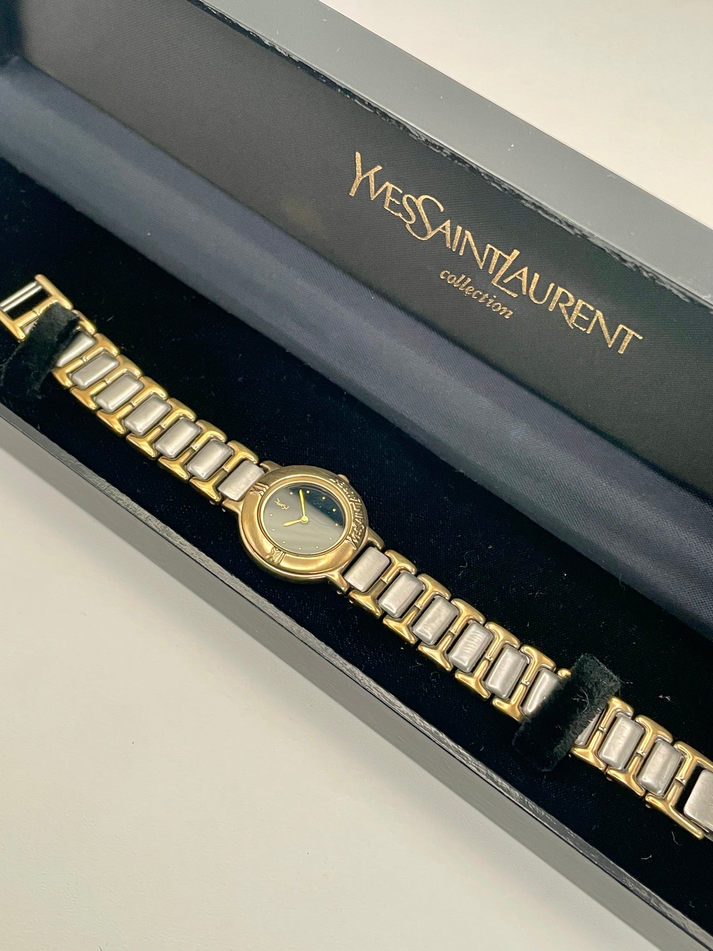 Top view of the YSL Black Pour Femme watch showing full length of the two-tone bracelet.