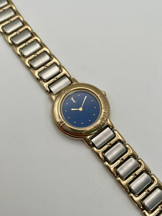 Diagonal view of YSL Blue Pour Femme vintage watch showing blue dial and gold case.

