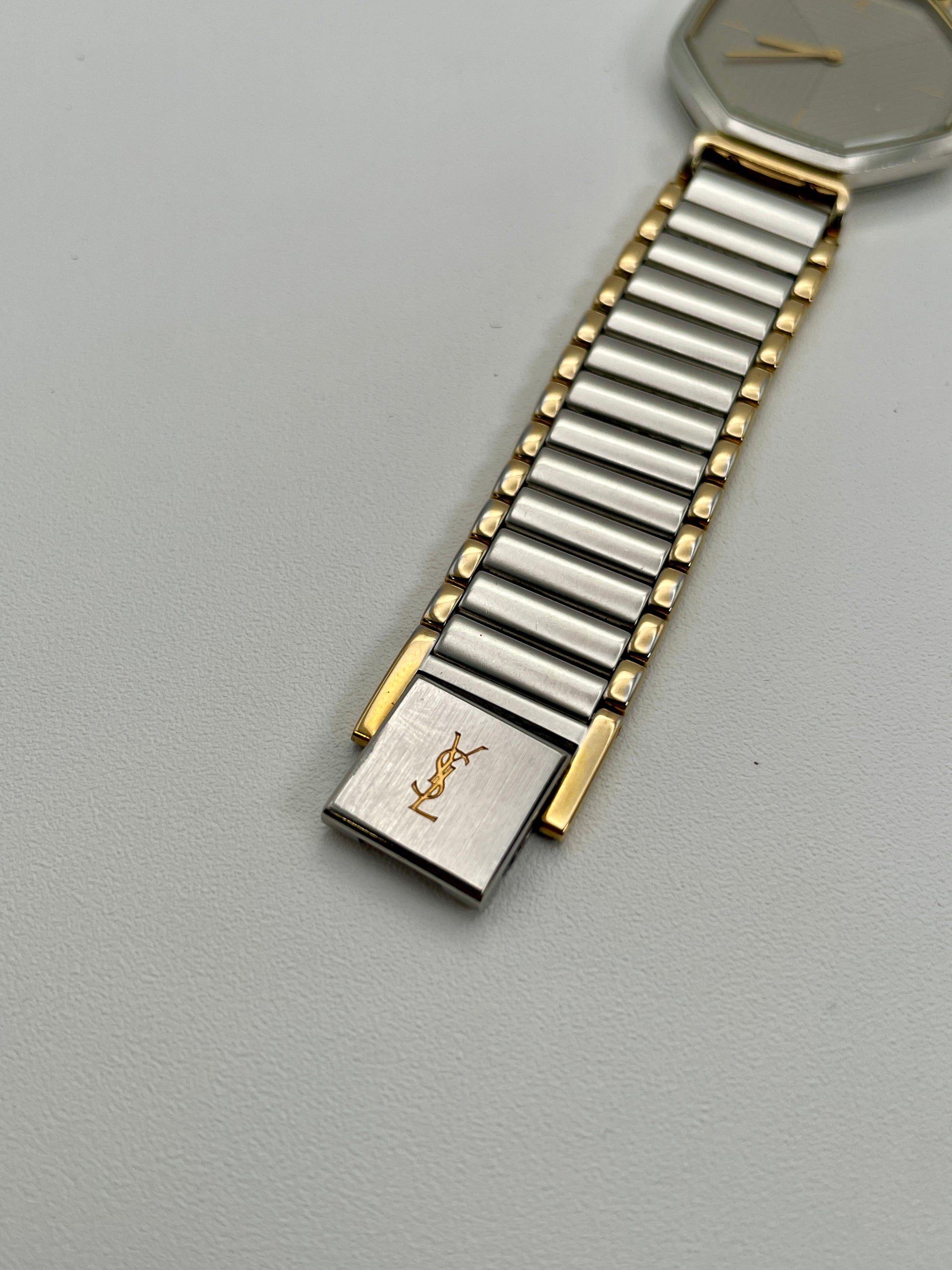 Close-up of clasp on YSL two-tone bracelet with YSL logo engraving
