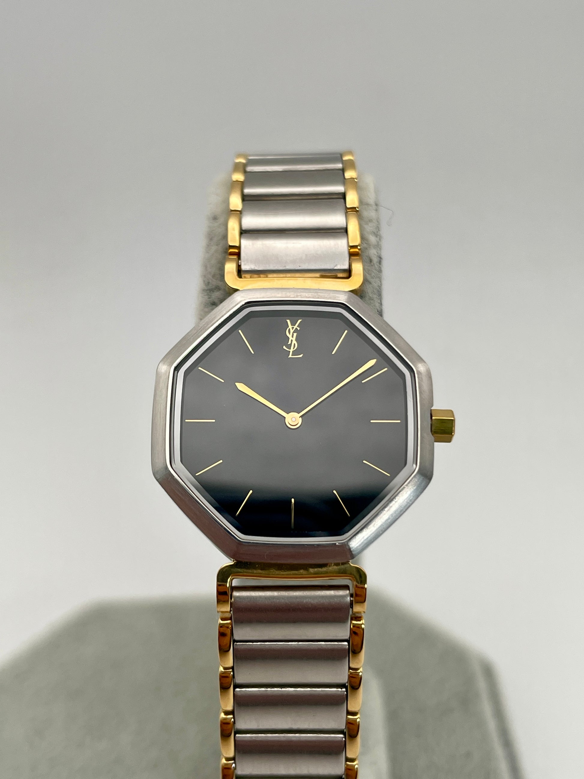 Front view of the Yves Saint Laurent Octagon Vintage Women's Watch featuring a black dial and gold hour markers.