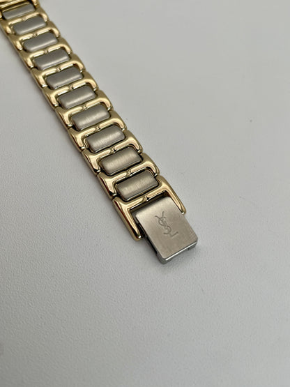 Close-up view of the clasp on Yves Saint Laurent vintage ladies  Pour Femme watch's two-tone bracelet.