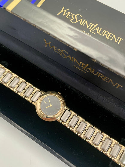 Yves Saint Laurent YSL Pour Femme watch with gold case, black dial, and two-tone bracelet, shown with original box.