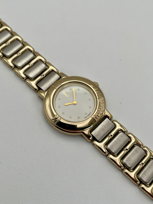 YSL Pour Femme watch with gold case, white dial, and two-tone bracelet.