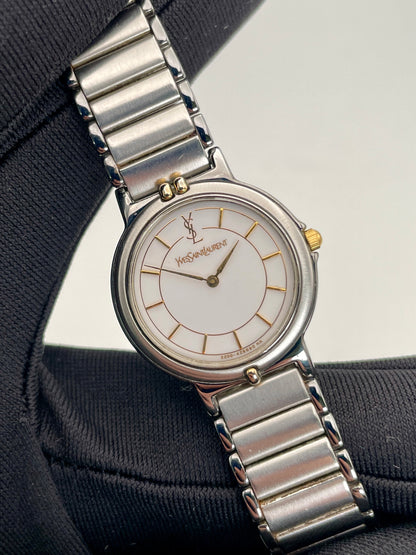 Closer view of the vintage Yves Saint Laurent two-tone watch, focusing on the stainless steel and gilt case and white dial.