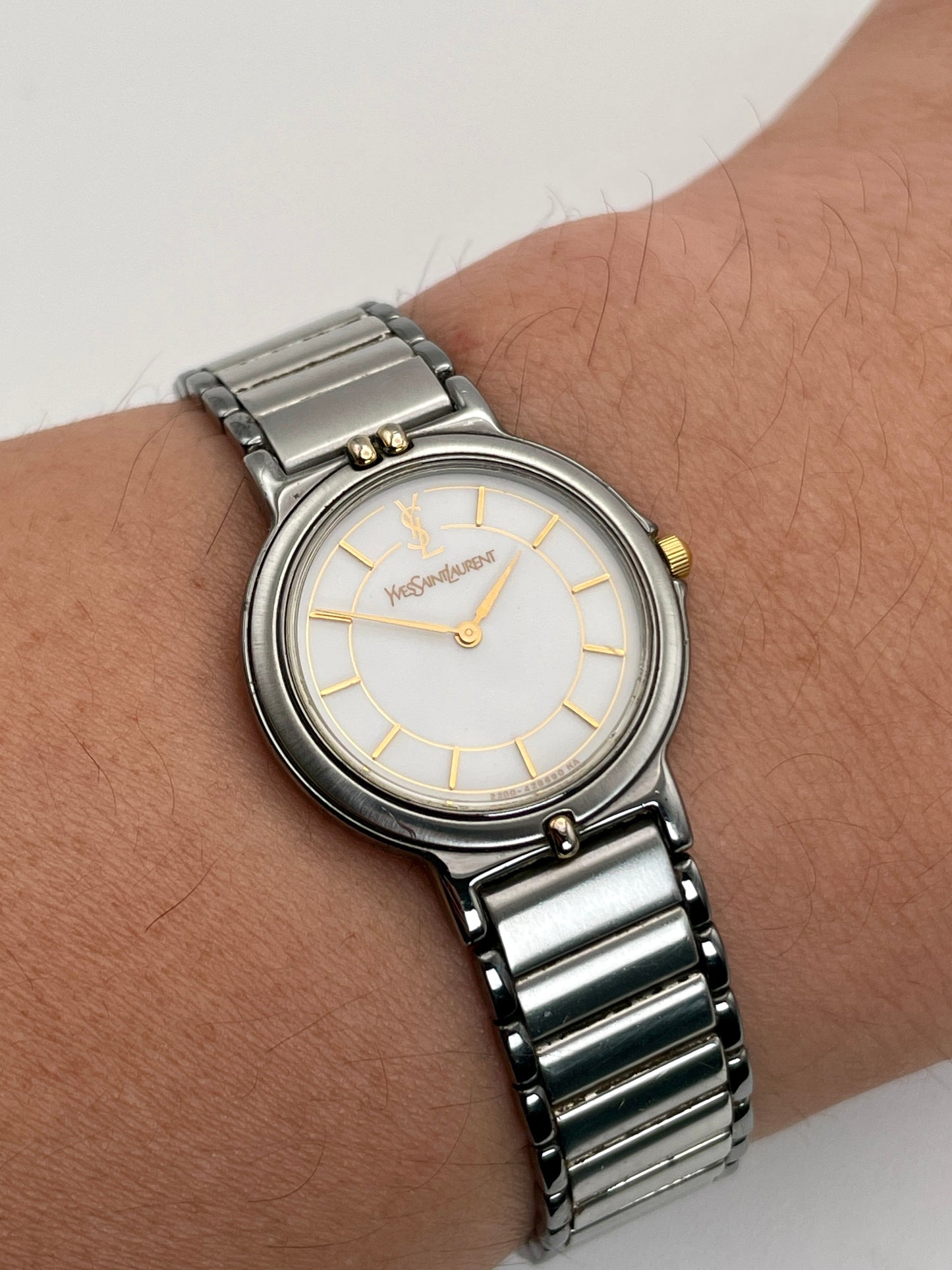 Closer wrist shot view of Vintage Yves Saint Laurent two-tone watch worn on wrist, showcasing the stainless steel and gilt case with a matching bracelet.