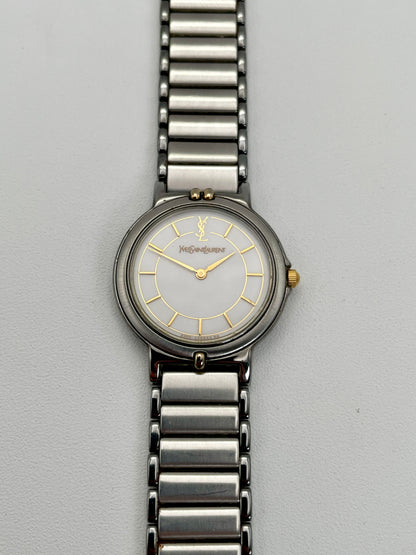 Front view of the vintage Yves Saint Laurent two-tone watch, showcasing the stainless steel and gilt case with a white dial.