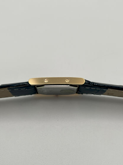 Left side profile of the YSL Tank watch showing flat gold case and screw details