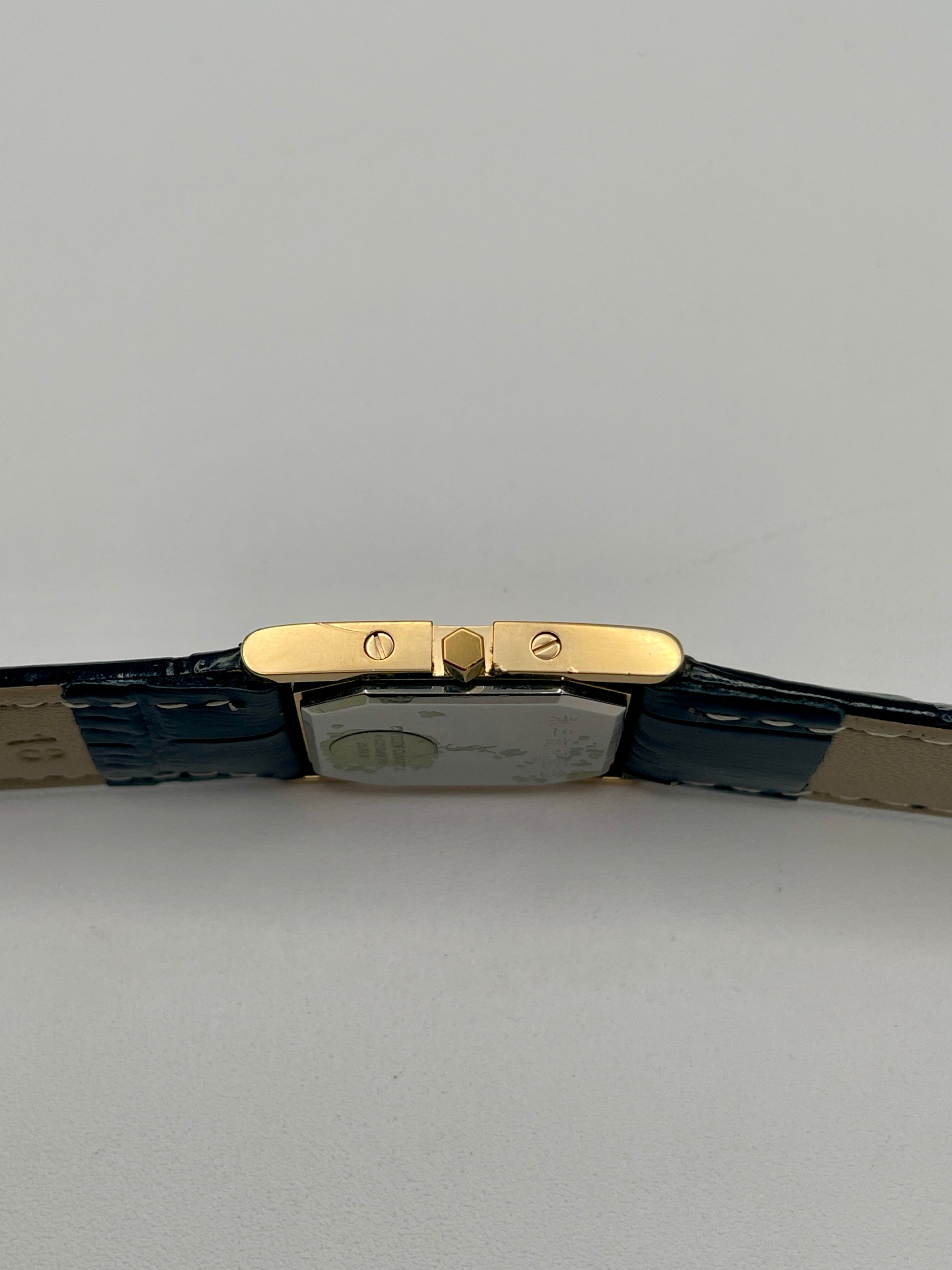 Right side view of the YSL watch showing the gold crown and screw accents