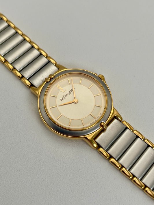 Angled view of a YSL vintage two-tone watch featuring a silver dial with gold accents and a two-tone metal bracelet.