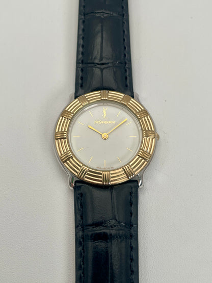 Full front view of Yves Saint Laurent vintage watch featuring a white dial and gold-tone bezel.
