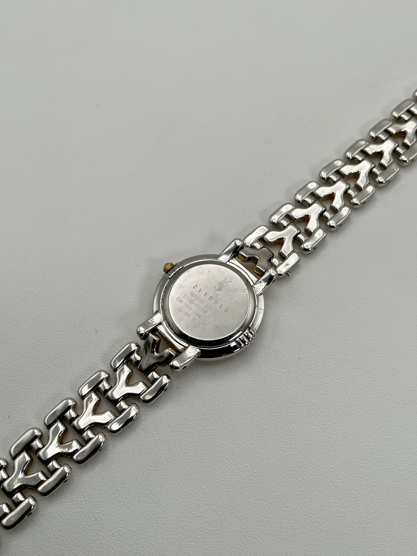 Caseback view of Yves Saint Laurent vintage women's watch showing engraved details and serial number
