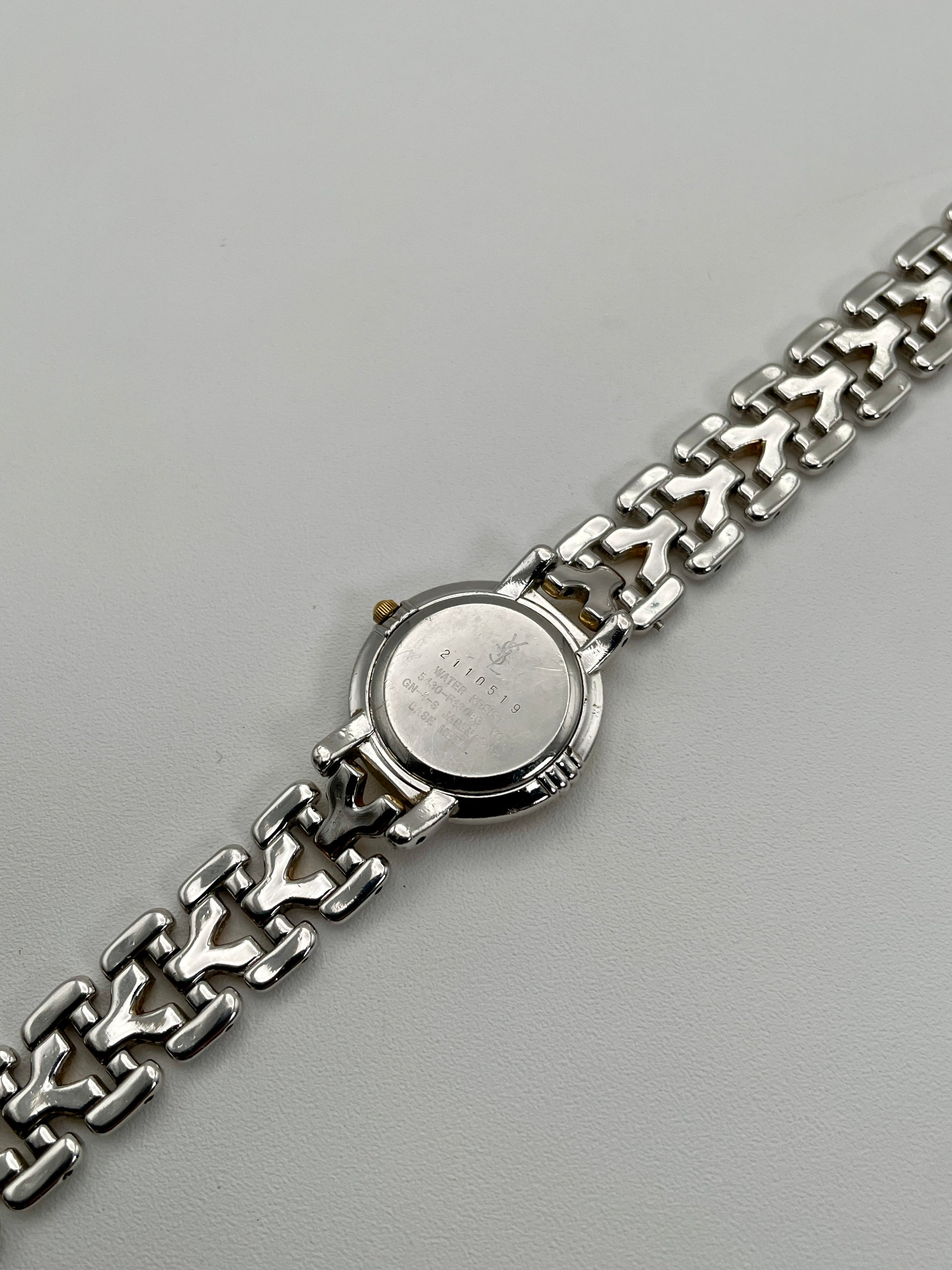 Caseback view of Yves Saint Laurent vintage women's watch showing engraved details and serial number
