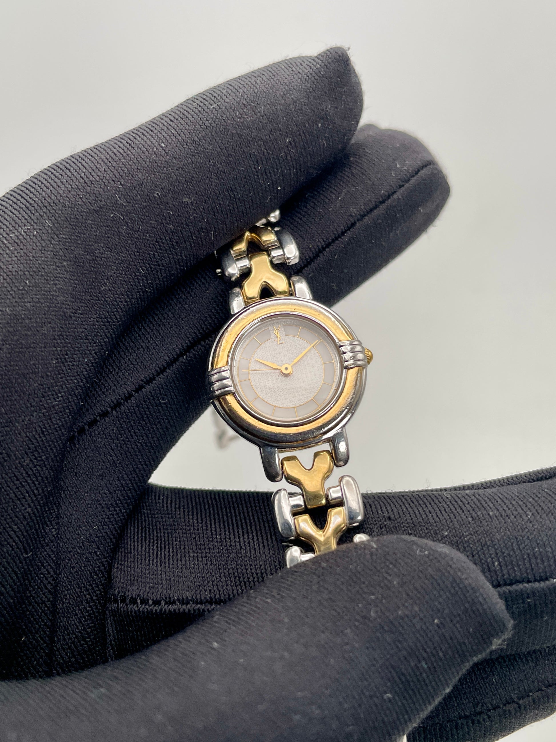 Close-up view of Yves Saint Laurent vintage women's watch focusing on the dial and bracelet texture
