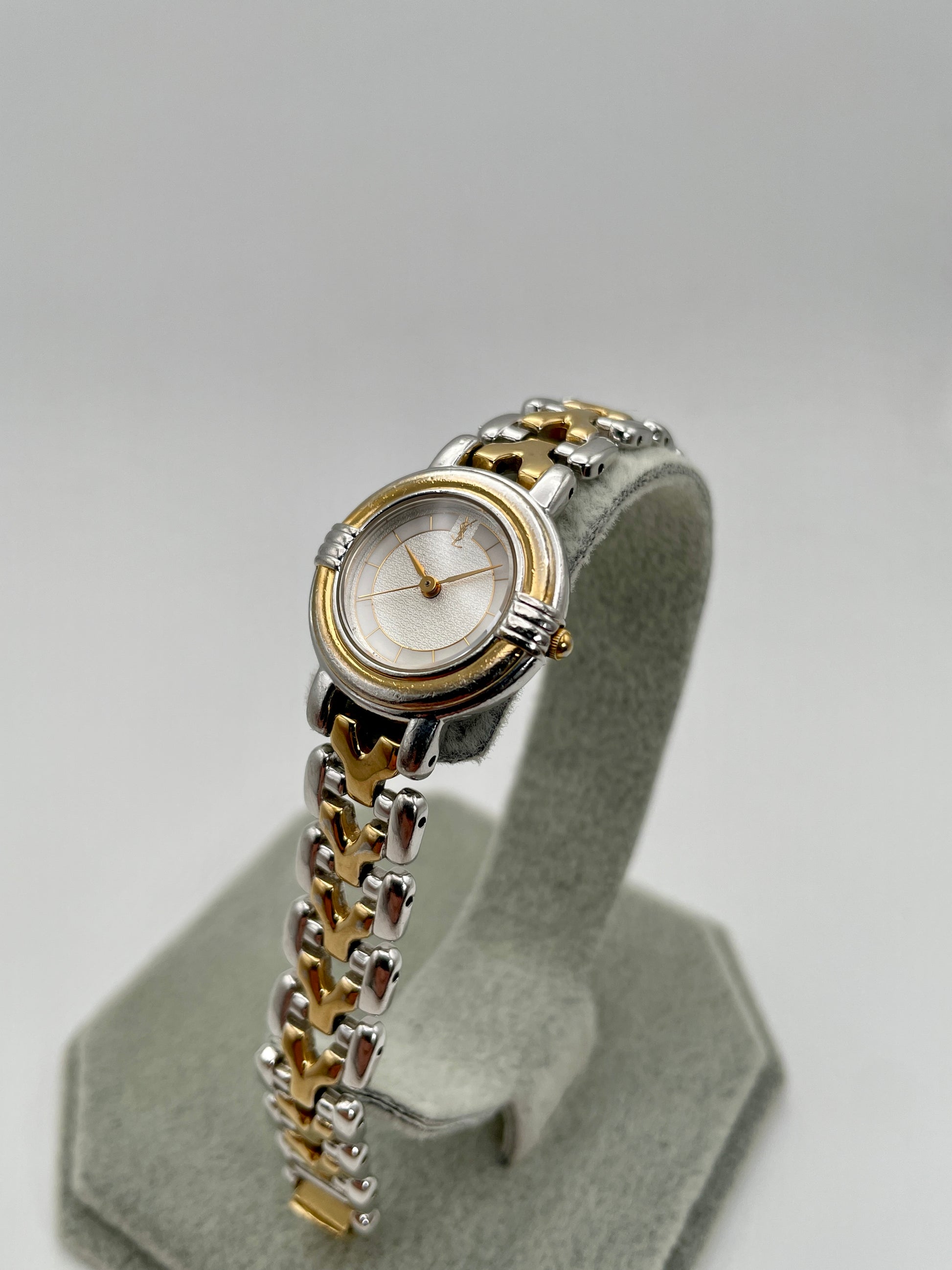 Diagonal view of Yves Saint Laurent vintage women's watch highlighting the gold bezel and two-tone bracelet links
