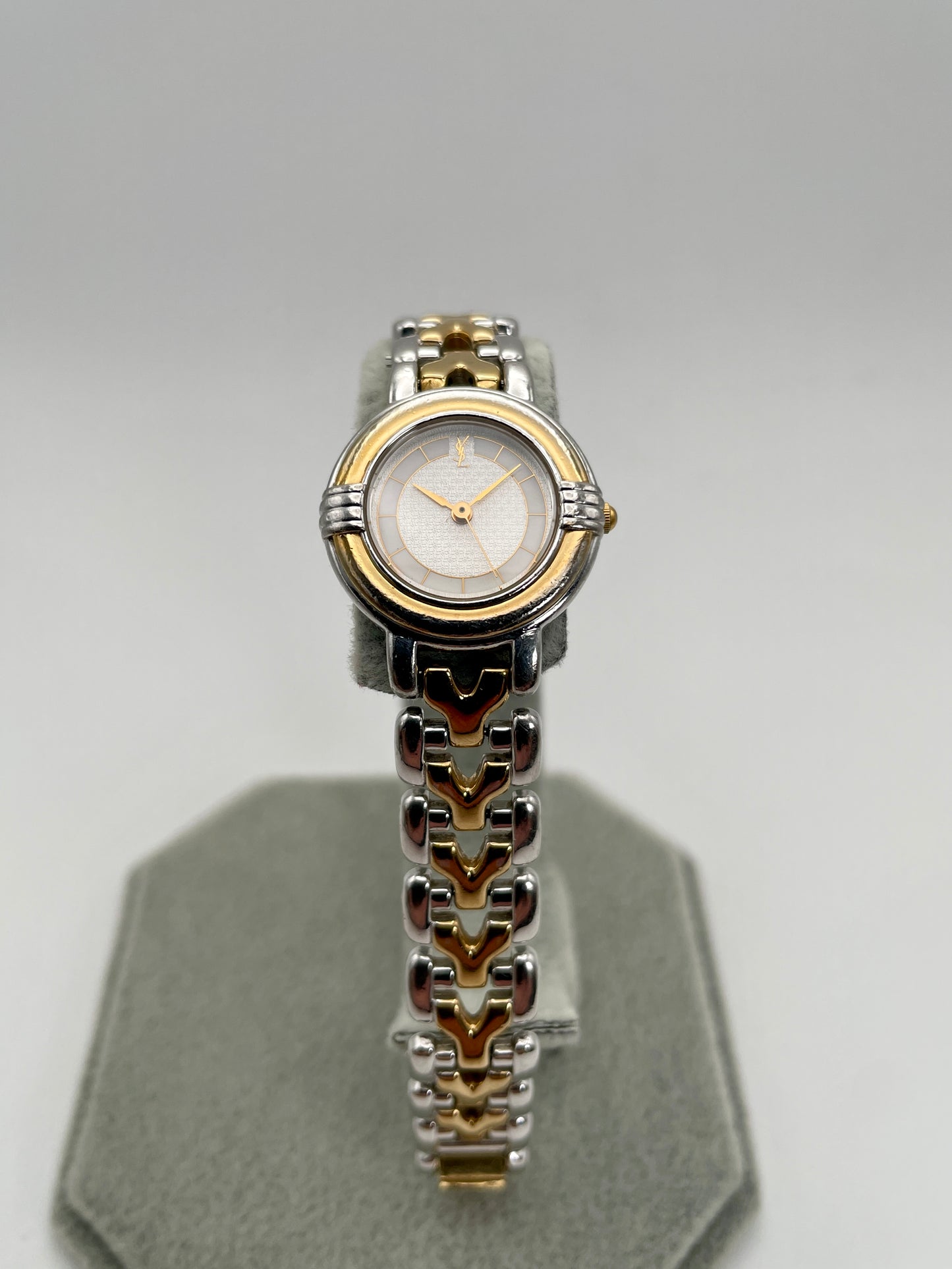Front view of Yves Saint Laurent vintage women's watch showing the full dial with gold-tone hands and logo at 12 o'clock
