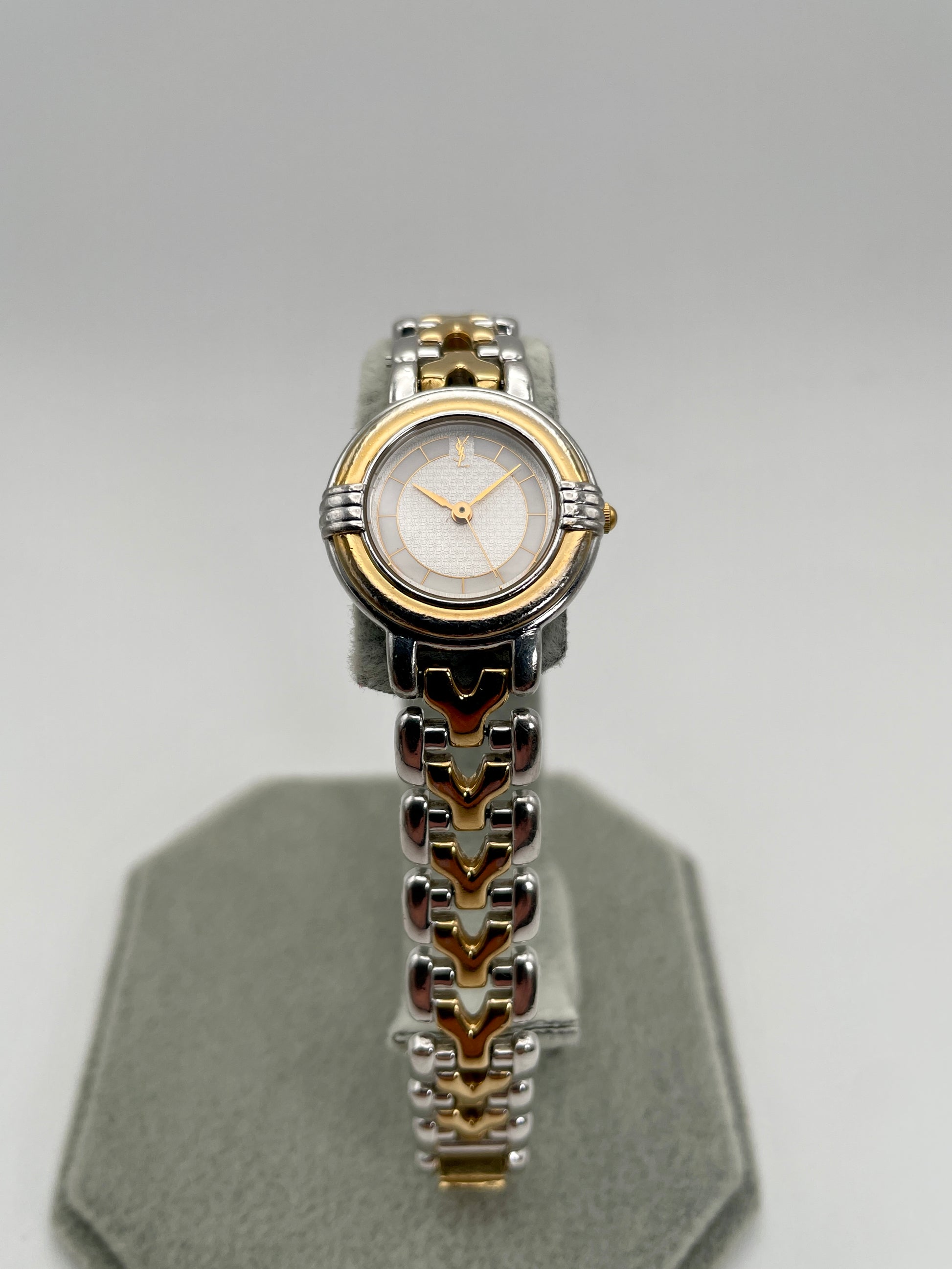 Front view of Yves Saint Laurent vintage women's watch showing the full dial with gold-tone hands and logo at 12 o'clock
